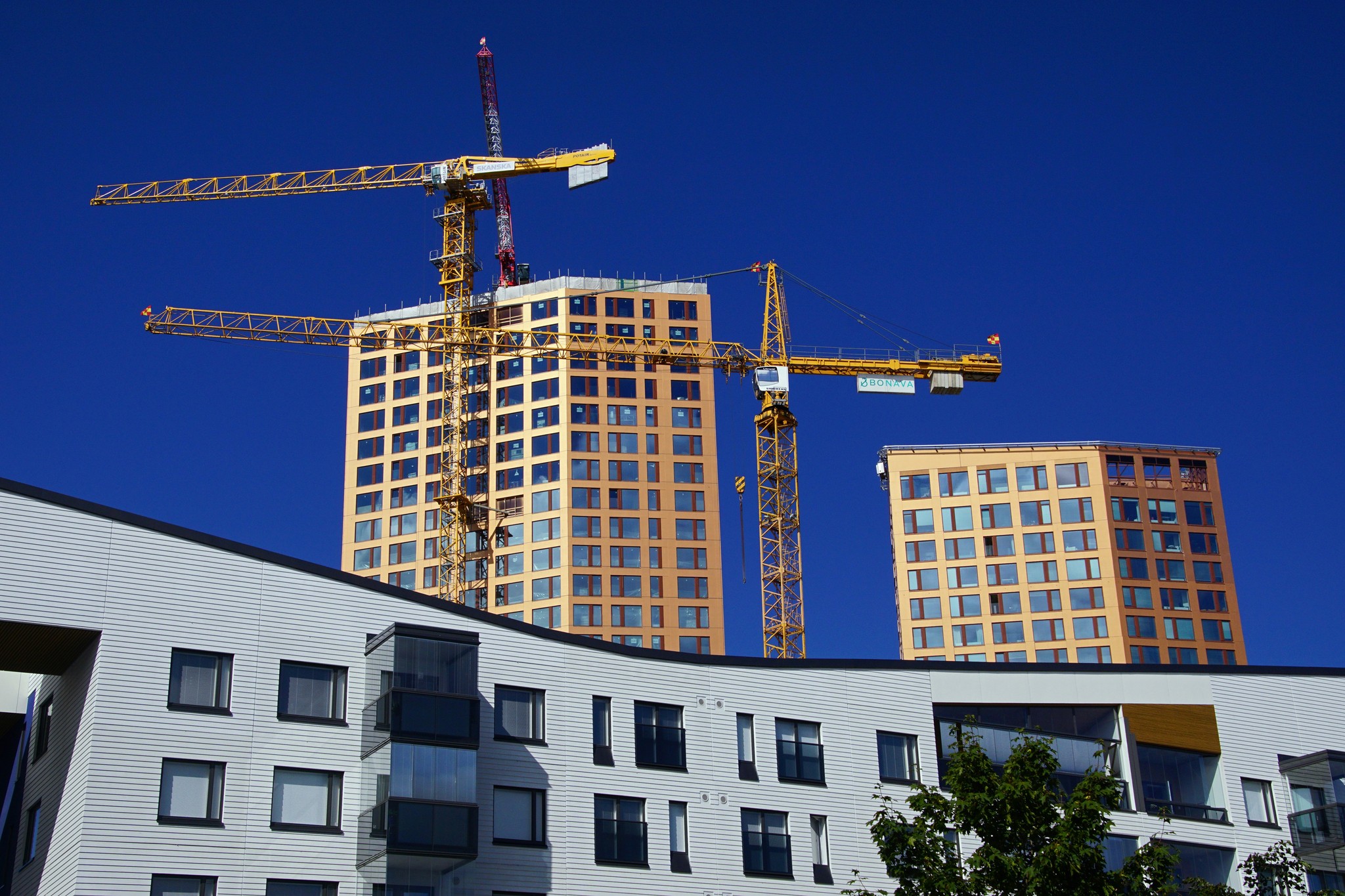 a building under construction with cranes in the background